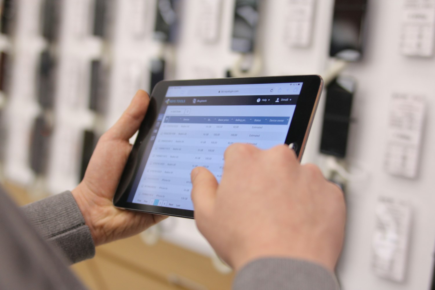 Persona consultando un listado de productos en una tablet dentro de un depósito