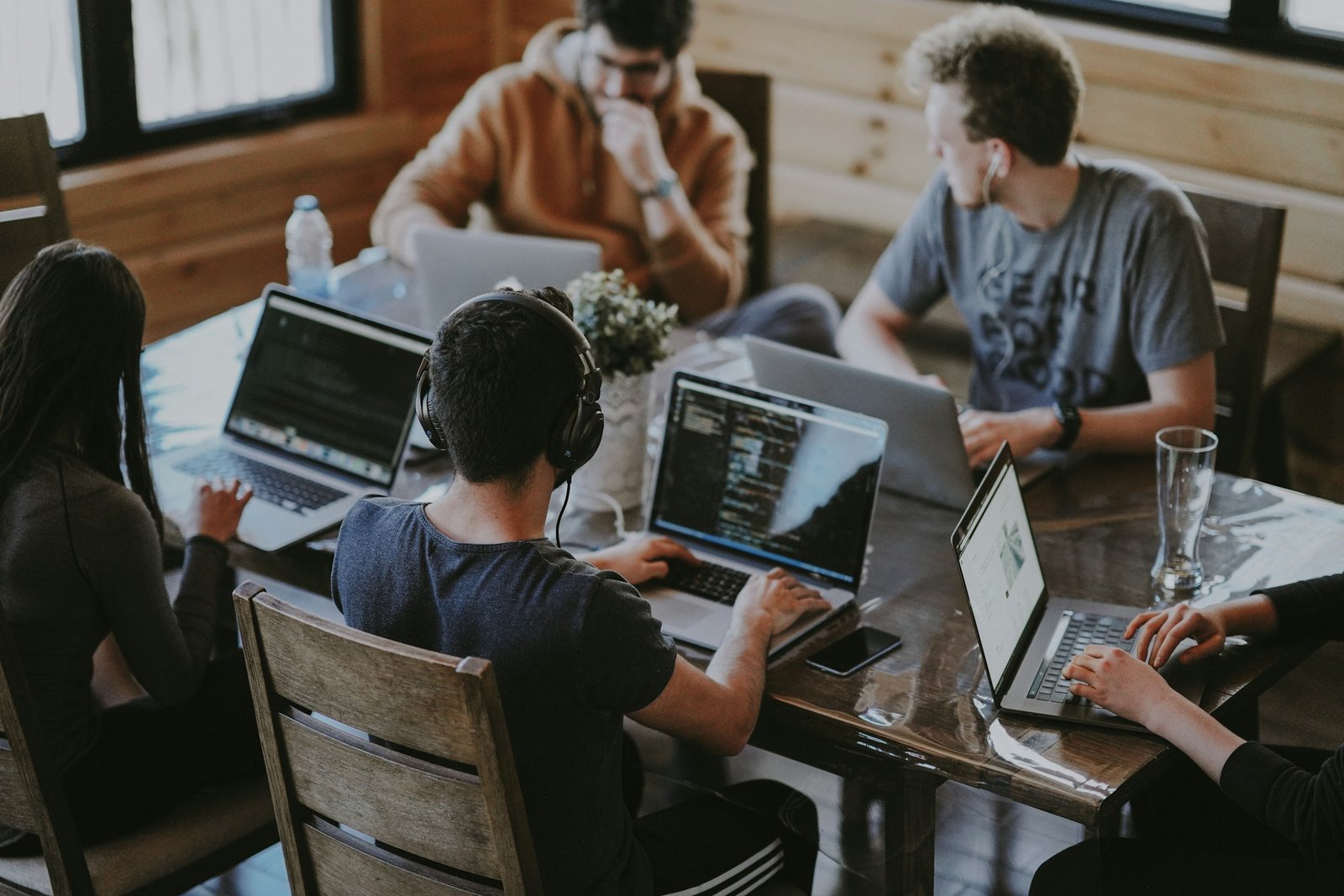 Equipo de trabajo reunido alrededor de una mesa con varias notebooks